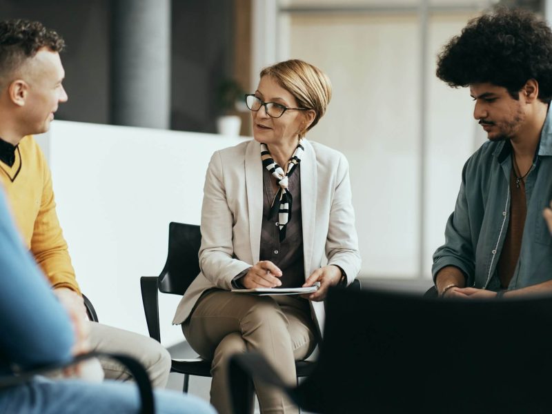 mature-therapist-talking-to-participants-of-group-therapy-at-mental-health-center-.jpg mature-therapist-talking-to-participants-of-group-therapy-at-mental-health-center-.jpg